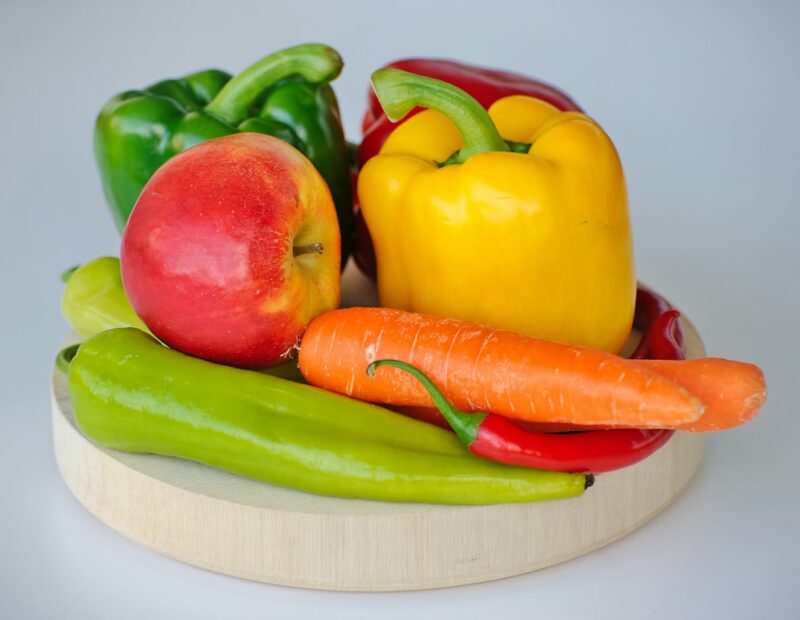 red and green bell pepper and red apple on white plate