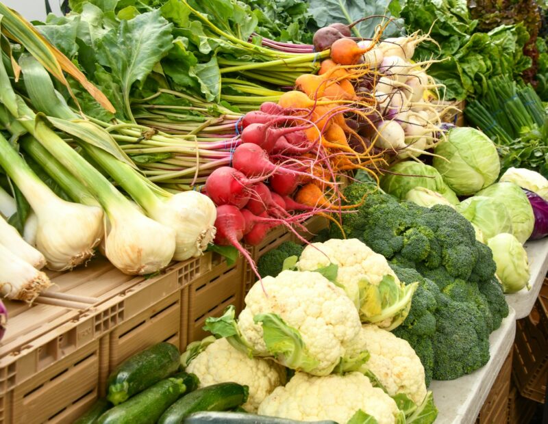 green and red vegetable on brown wooden table